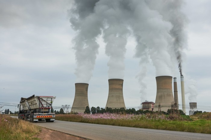 Un camion de livrare trece pe lângă un turn de răcire al Eskom în provincia Mpumalanga, bogată în cărbune, în estul Africii de Sud