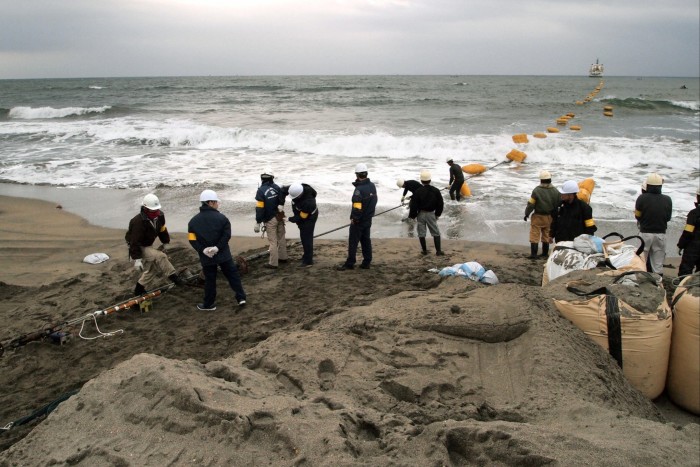 China își exercită controlul asupra proiectelor de cabluri de internet în Marea Chinei de Sud Muncitori din Japonia trag un cablu submarin de fibră optică de pe o navă în Minamibōsō