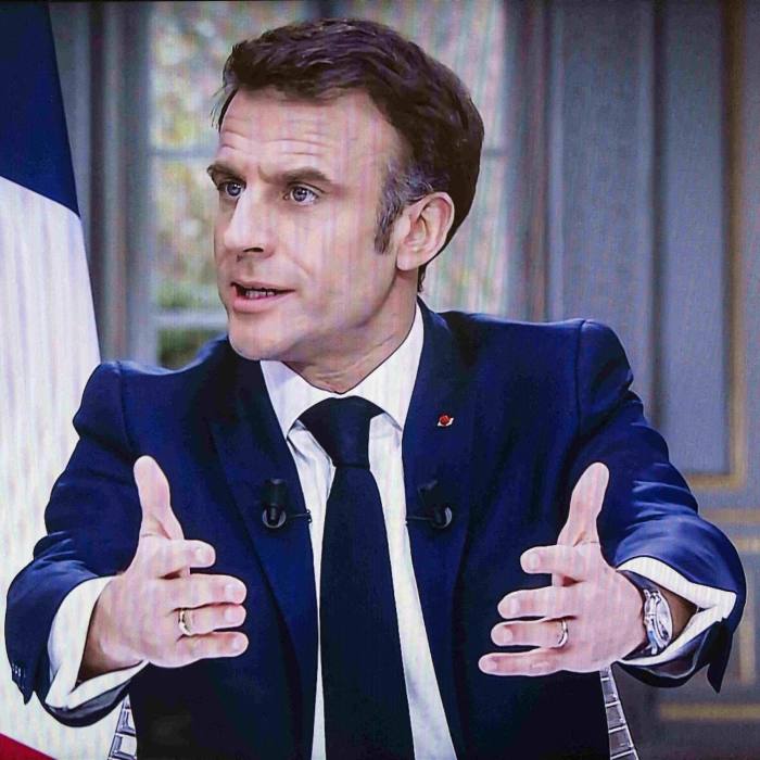 Președintele Emmanuel Macron gesticulează în timp ce vorbește la televizor