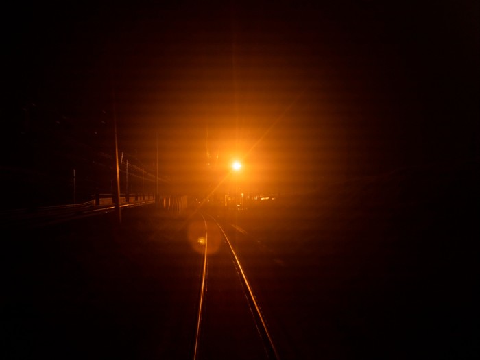 Naraţiunea trenurilor de noapte O lumină strălucește în depărtare, peste o vedere nocturnă a căilor ferate