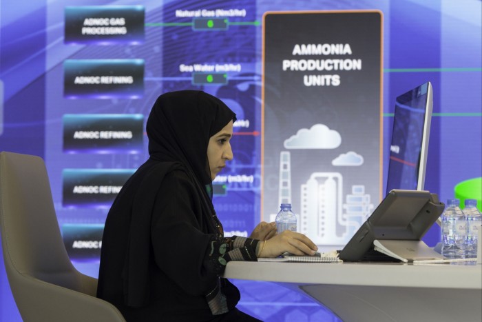 Un angajat lucrează lângă un ecran digital care afișează unitățile de producție de amoniac la sediul Adnoc din Abu Dhabi