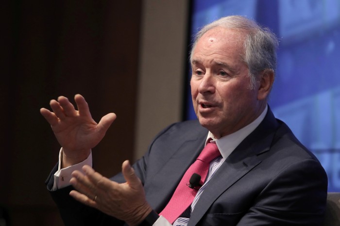 Schwarzman, îmbrăcat la costum și cravată, gesticulează cu mâinile