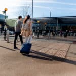 full shot couple walking with baggage