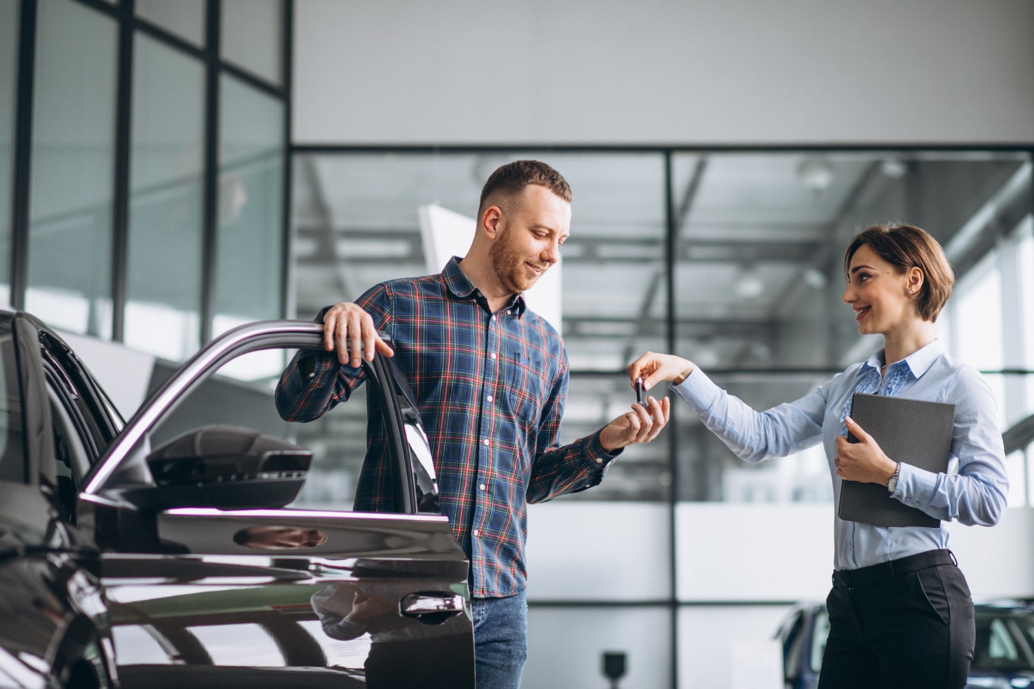 young handsome man choosing car car showroom