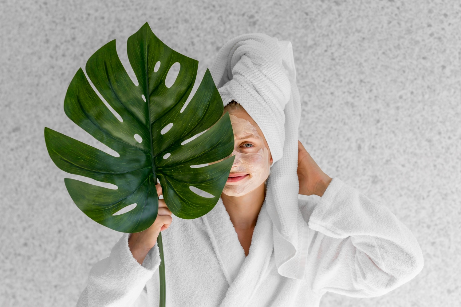 front view woman holding monstera leaf